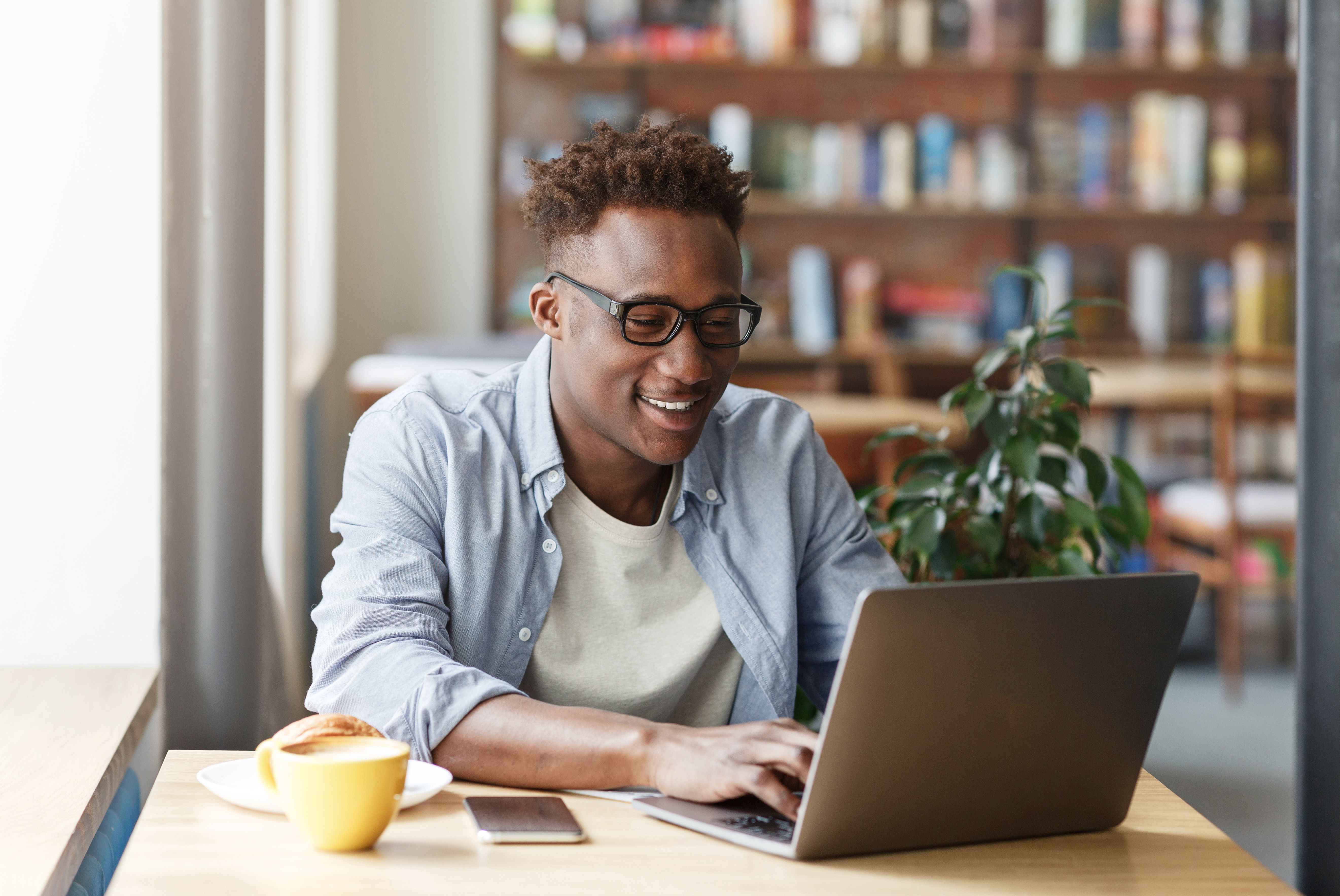 joyful african american student doing his online homework